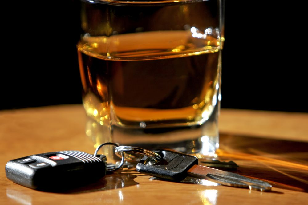 Glass of scotch next to car keys